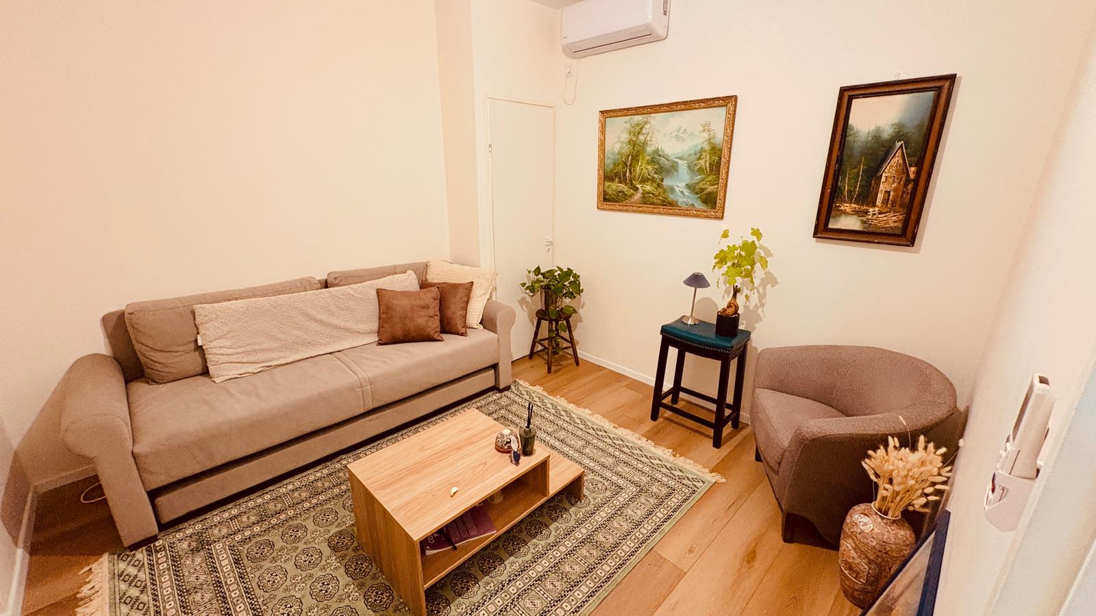 Therapy office seating area with a sofa, armchair, and plants